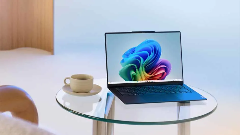 Een laptop met een kleurrijk scherm staat op een glazen tafel, naast een kop koffie op een schotel.