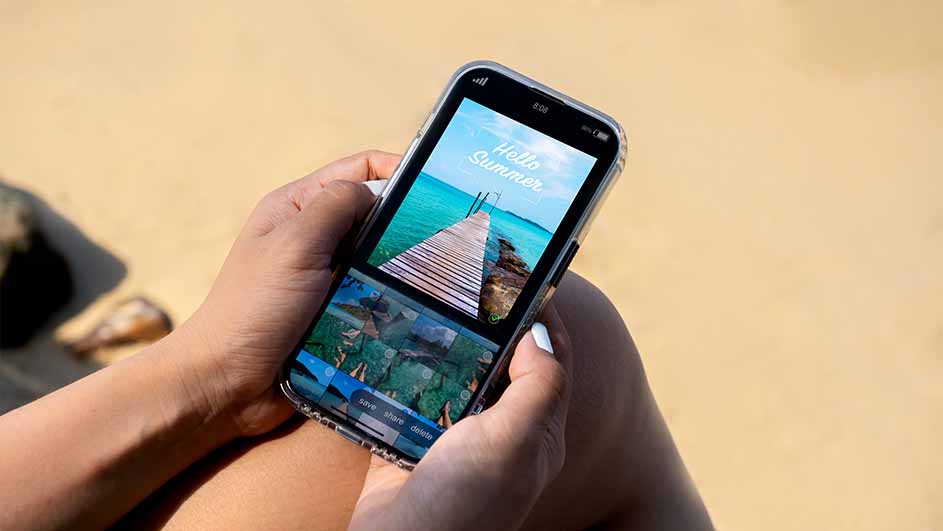 Een telefoon met beelden van een houten steiger over blauw water wordt vastgehouden tegen een beige achtergrond.