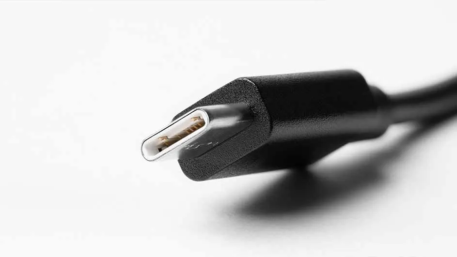 Een close-up van een zwarte USB-C-stekker met een zilverkleurige metalen punt tegen een witte achtergrond.