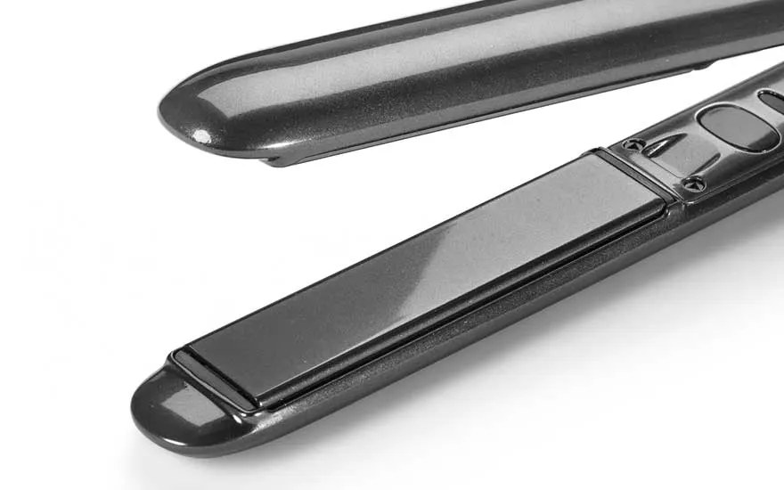 A black hair straightener is shown in close-up, open on a white background, with sleek and shiny heated plates.