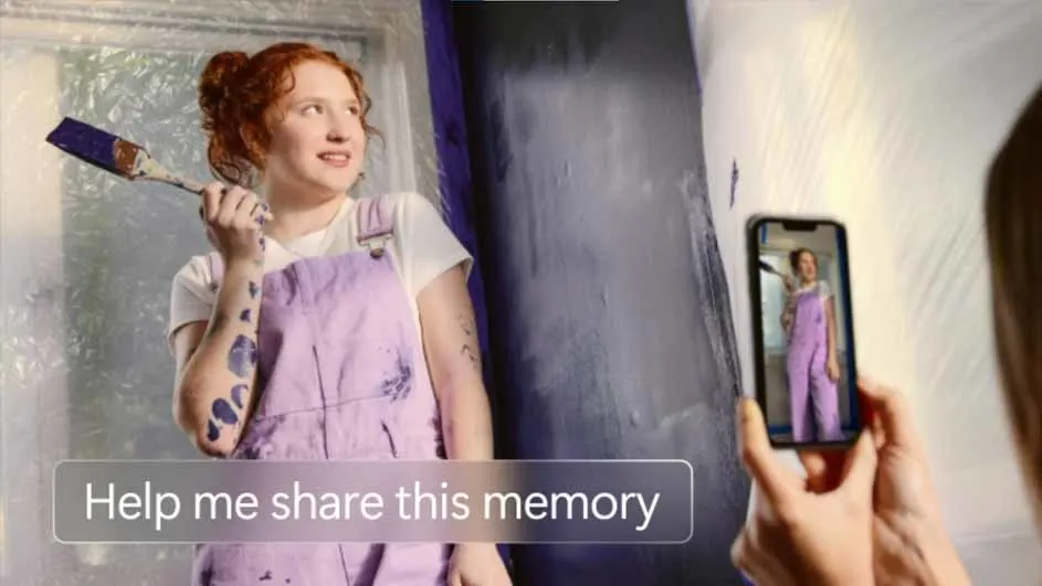 Vrouw met verfkwast en paarse overall staat voor een muur die geverfd wordt. Foto wordt gemaakt met een telefoon.