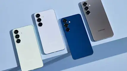 Vier Samsung-smartphones liggen schuin op een lichtblauwe ondergrond en tonen hun achterkant met driedubbele camera’s in diverse kleuren.