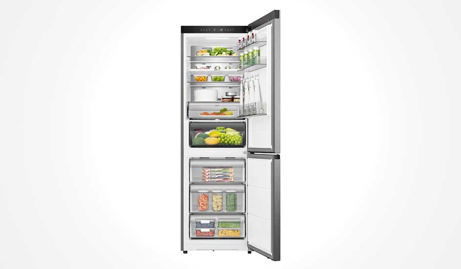 Een zilveren Hisense koelkast met ondervriesvak staat open. Binnen zie je groenten, fruit, drank, potjes en diepvriesproducten, netjes ingedeeld.