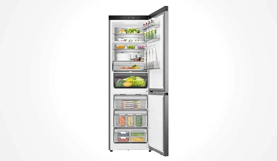 Een zilveren Hisense koelkast met ondervriesvak staat open. Binnen zie je groenten, fruit, drank, potjes en diepvriesproducten, netjes ingedeeld.