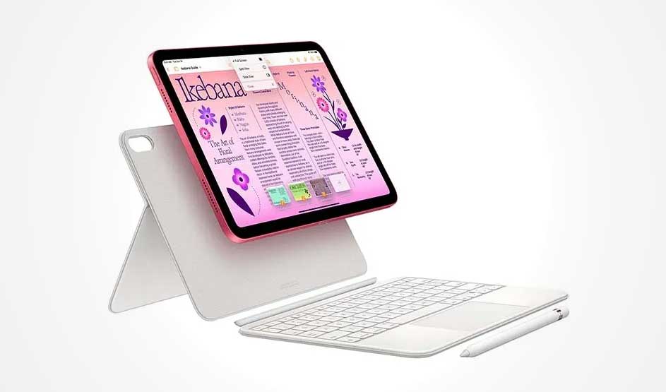 Een roze iPad staat op een witte standaardhoes; op het scherm een lay-out met tekst en paarse bloemen, met een wit toetsenbord en stylus ervoor.