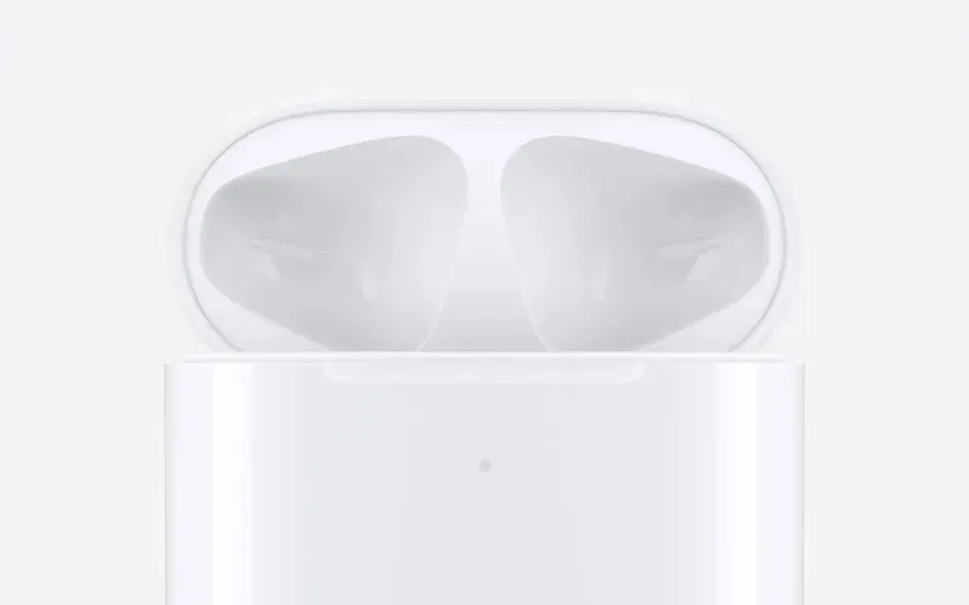 Close up van een glanzende witte AirPods oplaadcase, de binnenkant leeg en klaar om de oordopjes te ontvangen, minimalistisch in beeld.