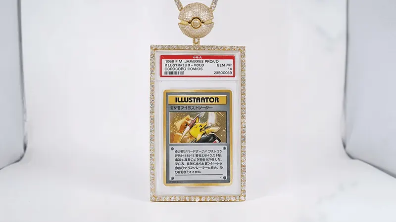Japanese Pokémon card "Illustrator" in a diamond frame, hanging from a gold Pokéball chain, rare collector's item.