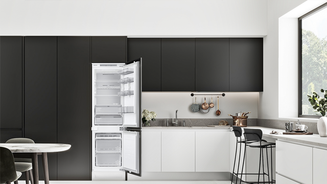 Zicht op een moderne keuken met zwarte kasten, witte aanrechtbladen en een openstaande witte koelkast.