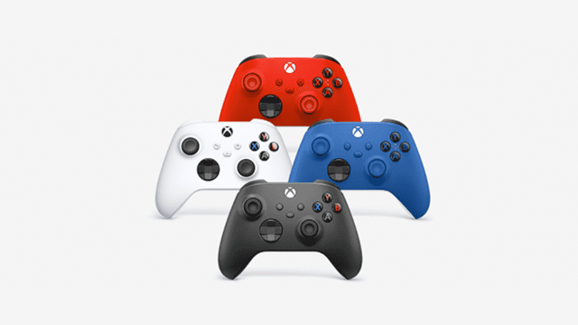 Vier Xbox-controllers in zwart, wit, blauw en rood liggen op een witte achtergrond.
