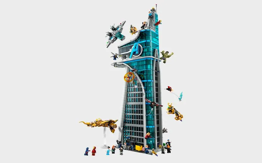 LEGO Avengers-toren met blauwe ramen, helden, voertuigen en actiefiguren die rondom het hoge gebouw vliegen en strijden.