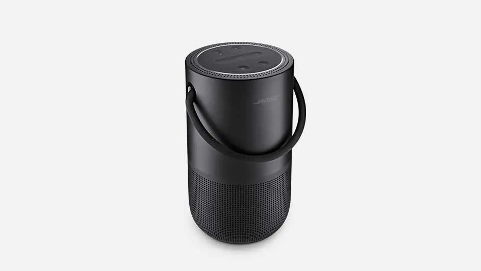 Een zwarte, cilindervormige draagbare luidspreker met een handvat, staat op een witte achtergrond.