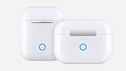 Two white earbud cases sit on a white surface. Each has a gray accent and a blue circle on the front.