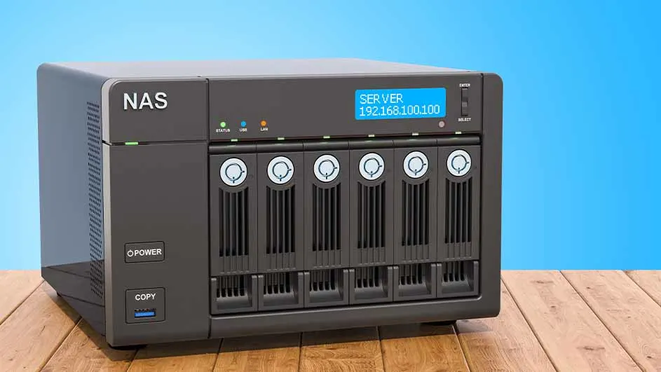 Zwarte NAS-server met zes schijfsloten staat op een houten oppervlak. Het display toont het IP-adres van de server tegen een blauwe achtergrond.