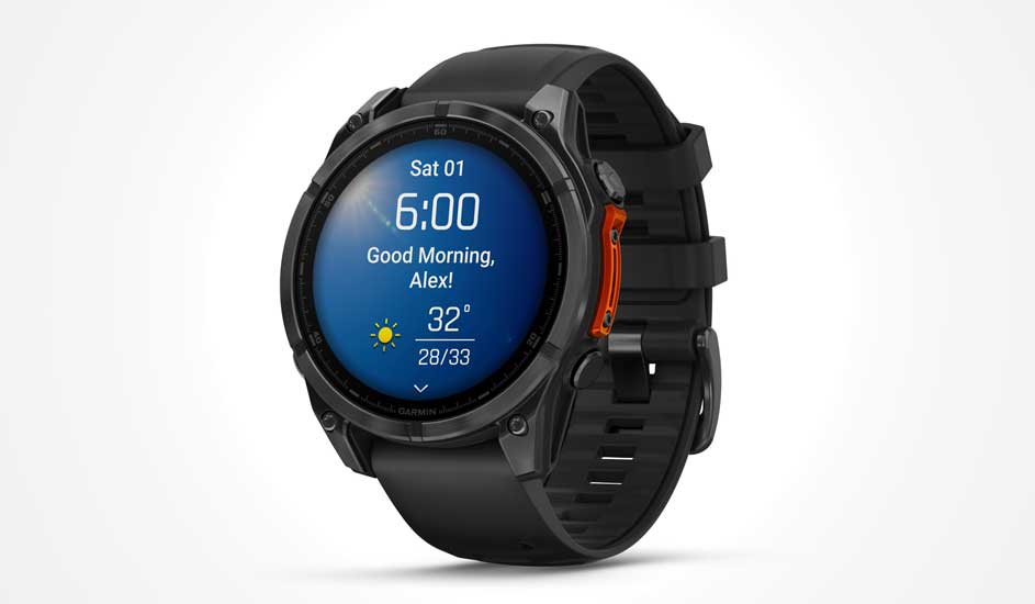 Een zwarte Garmin smartwatch met rond display toont de tijd, temperatuur, datum en een persoonlijk welkomsbericht op het scherm.