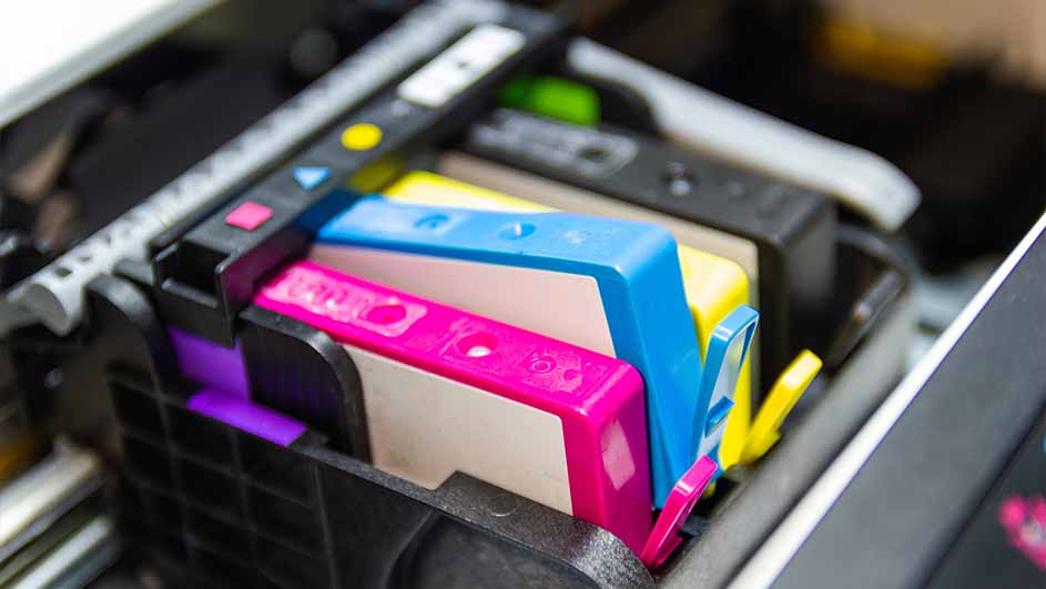 Inktcartridges in een printer, kleuren magenta, blauw, geel en zwart.