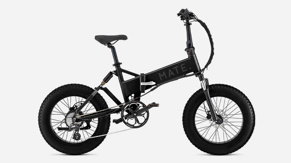 Een zwarte elektrische vouwfiets met dikke banden staat zijdelings op een witte achtergrond. Het frame is voorzien van het merk MATE.