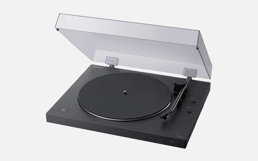 Sleek black plastic turntable with clear lid, minimalist controls and tonearm on the right, shown against a pale background.