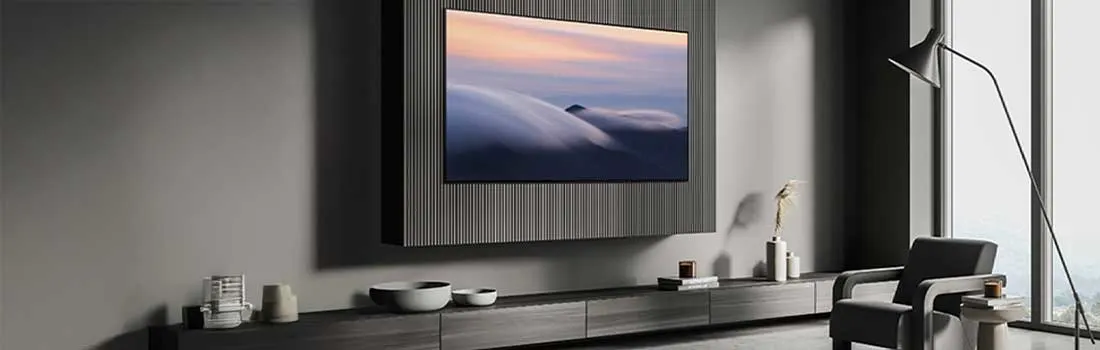 Minimalistisch interieur met een grote tv aan de wand. Grijze meubels, lange ramen en een vloerlamp geven het geheel een luxe uitstraling.