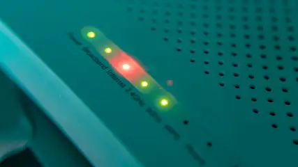 Groen apparaat met ventilatiegaten en LED-indicatielampjes, waarvan één rood en de andere geel zijn.
