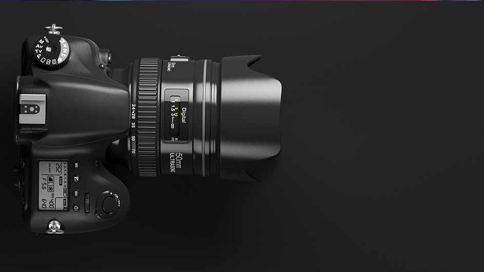 Een zwarte digitale spiegelreflexcamera met een 50mm lens ligt op een zwarte achtergrond.