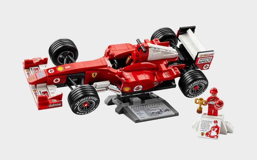 Rode LEGO Ferrari Formule 1-auto op een standaard, met racebanden, stickers, trofee, pilootfiguur en displayplaat.