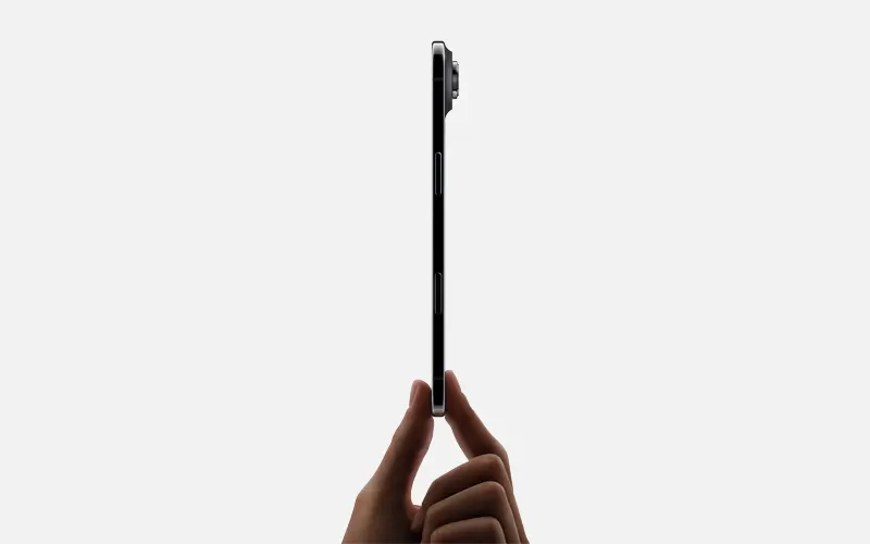Zijaanzicht van een ultradunne smartphone, rechtop gehouden tussen duim en vinger.