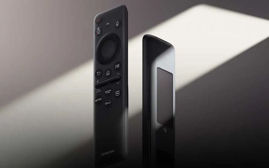 Zwarte Samsung afstandsbediening en streamingapparaat op wit oppervlak met zachte schaduweffecten in het zonlicht.