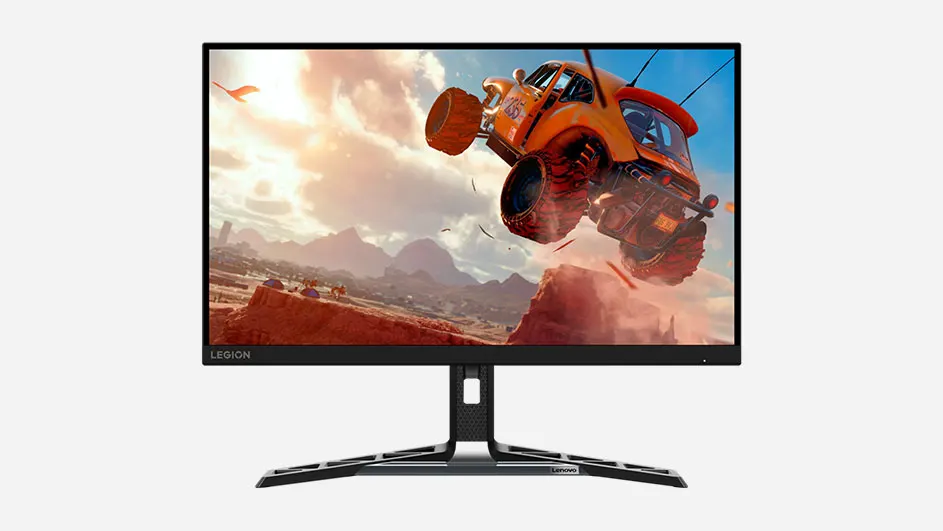 Een zwarte monitor toont een oranje auto die over een rots springt in een bergachtig landschap.