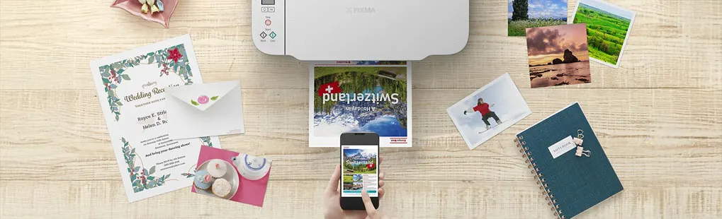 Een witte Canon printer print een foto van Zwitserland; iemand gebruikt een smartphone. Canon-logo zichtbaar op de printer.