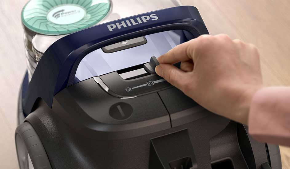 Een hand draait aan een knop op een Philips 3000 Series stofzuiger om de zuigkracht aan te passen.