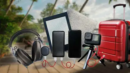 Verschillende reisgadgets zoals een GoPro op statief, powerbanks, smartphone, e-reader met hoes, oplaadkabels, draadloze oordopjes, koptelefoon en een rode koffer in een vakantiesetting.