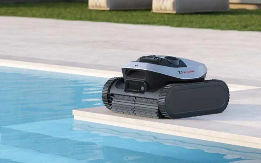 Een robot voor zwembadreiniging op rupsbanden staat aan de rand van het bassin, klaar om het water in te gaan.
