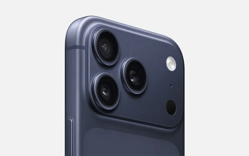 Close-up van een donkerblauwe smartphonehoek met drie cameralenzen en flitser.