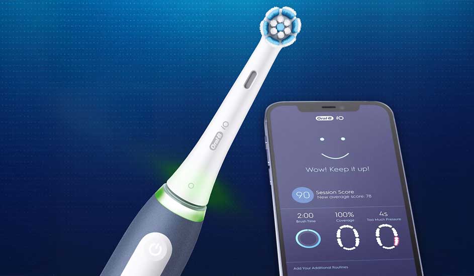 Een elektrische tandenborstel van het merk Oral-B staat naast een smartphone met de Oral-B app, die poetsscore en feedback toont.