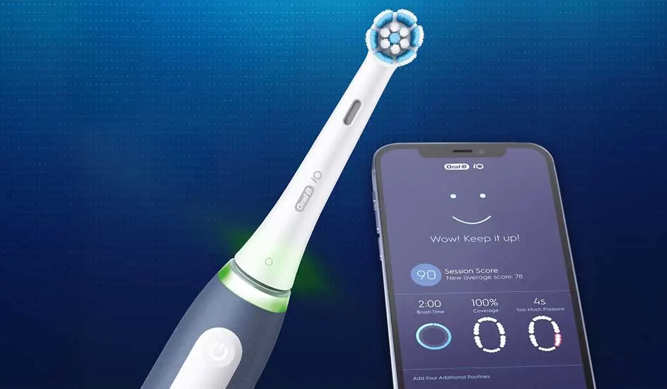 Een elektrische tandenborstel van het merk Oral-B staat naast een smartphone met de Oral-B app, die poetsscore en feedback toont.