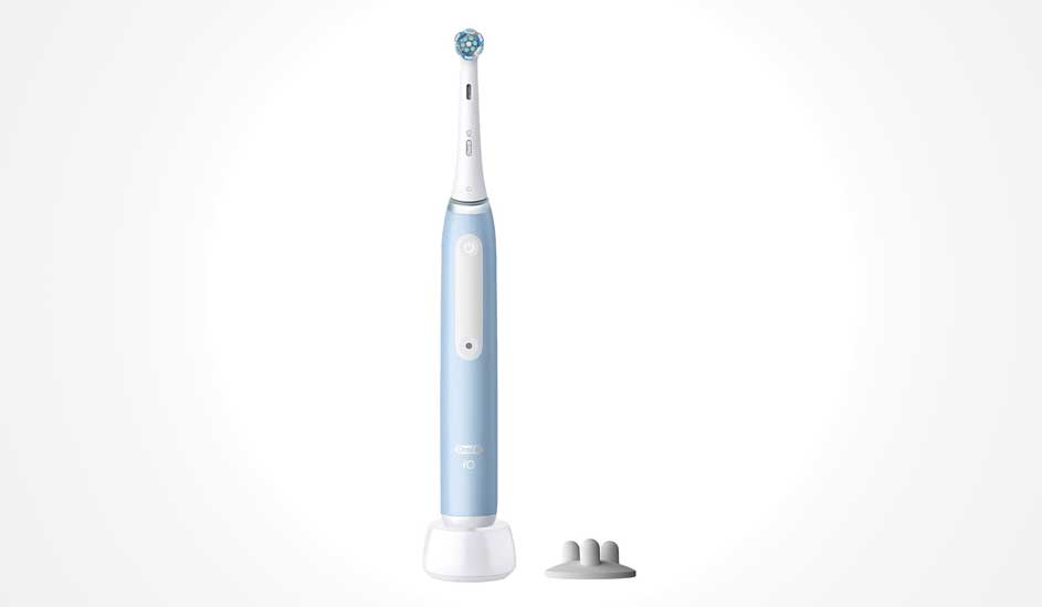 Een lichtblauwe Oral-B iO elektrische tandenborstel staat op een witte lader, met een houder voor opzetborstels ernaast. Modern ontwerp.