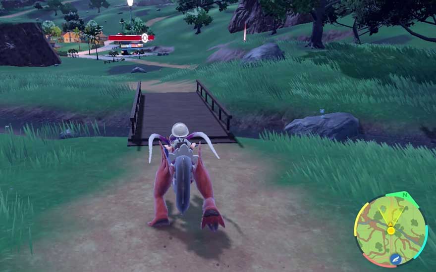 A mounted trainer rides a futuristic Pokémon across a wooden bridge towards a village and Pokémon Centre, guided by a colourful minimap bottom right.