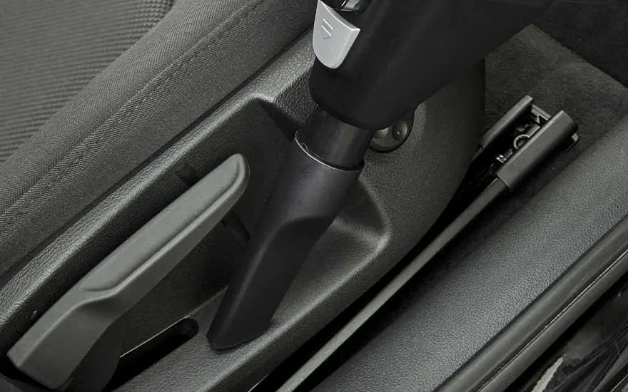 Close-up of a vacuum cleaner nozzle being used to thoroughly clean hard-to-reach areas inside the car for optimal cleanliness.