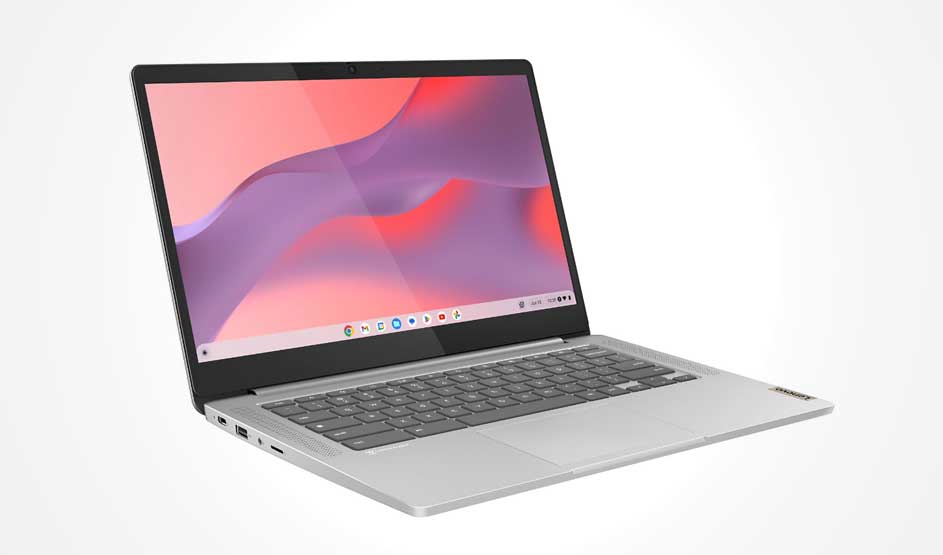 Een zilveren laptop schuin in beeld, open met een roze-paars bureaublad; toetsenbord, poorten en groot touchpad zijn duidelijk zichtbaar.