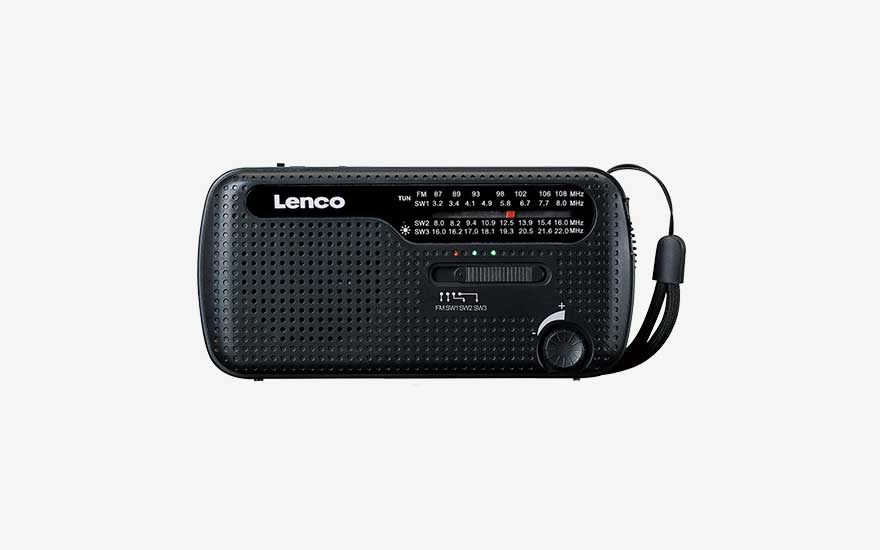 Compacte zwarte Lenco draagradio met analoge FM- en SW-schaal, geperforeerde luidspreker voorzijde, volumeknop en polsriem rechts.