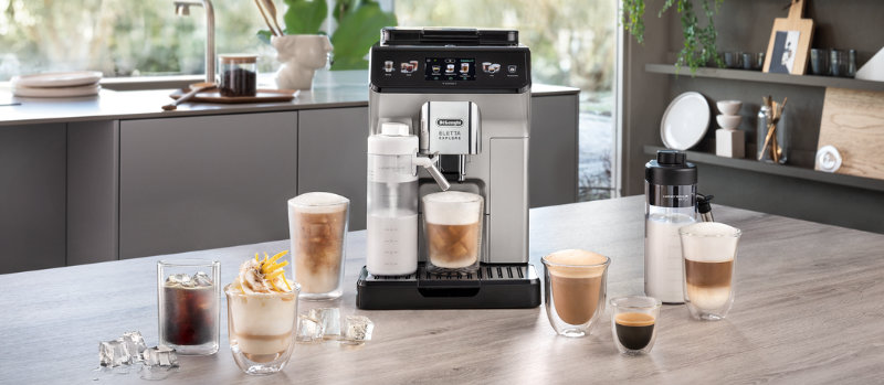 Een zilverkleurig koffiezetapparaat staat op een aanrecht, omringd door diverse glazen met koffie en ijsblokjes.