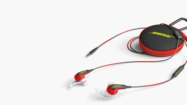 Rode oordopjes met snoer en een zwart hoesje met rood randje en geel logo liggen op een witte achtergrond.