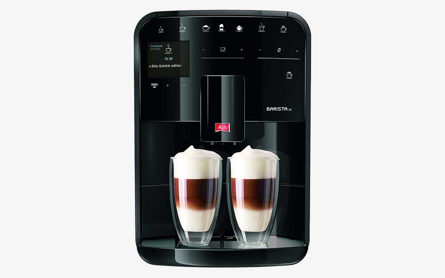 Black Melitta Barista coffee machine with two glass cups filled with layered coffee and milk foam.