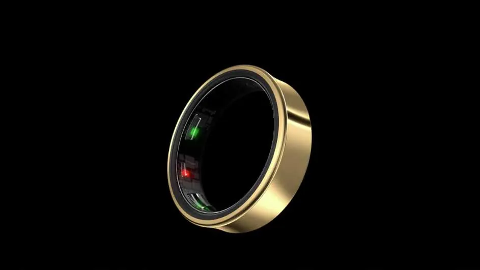 Gouden ring met zwarte binnenkant tegen een zwarte achtergrond. Er zijn rode en groene lichtjes zichtbaar aan de binnenkant van de ring.