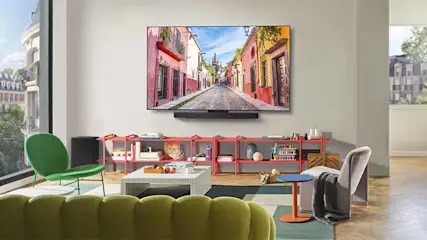Een moderne woonkamer met een aan de muur gemonteerde LG-televisie die een kleurrijke straat toont.