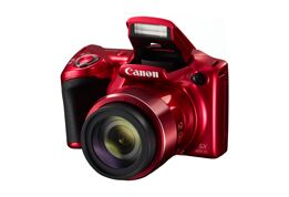 Rode Canon camera met open flitser, lens vooraan, op een witte achtergrond.