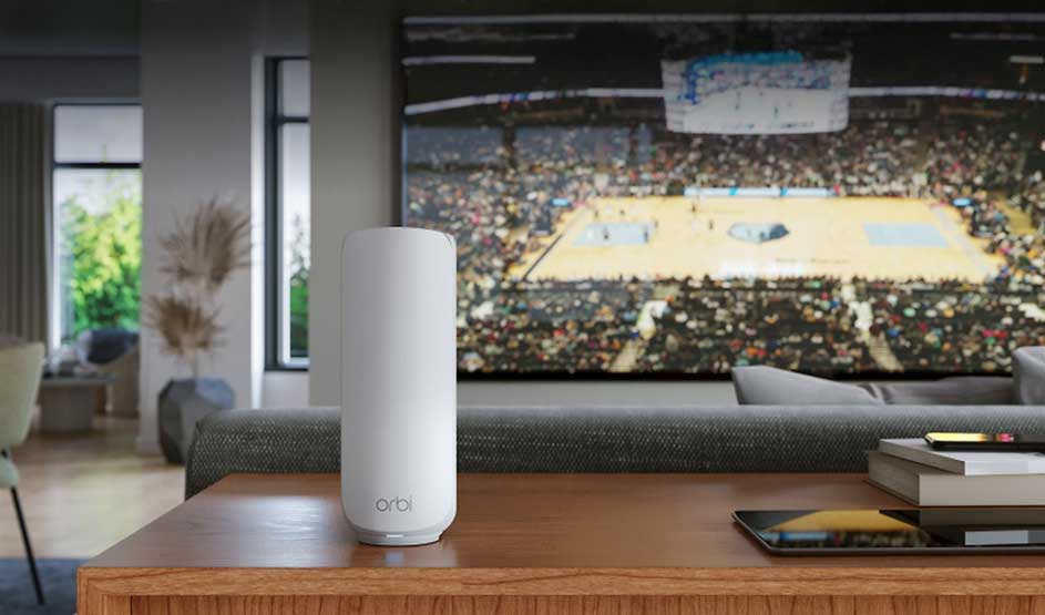 Een witte Orbi-router staat op een houten tafel; op de grote tv speelt een basketbalwedstrijd in een moderne woonkamer.