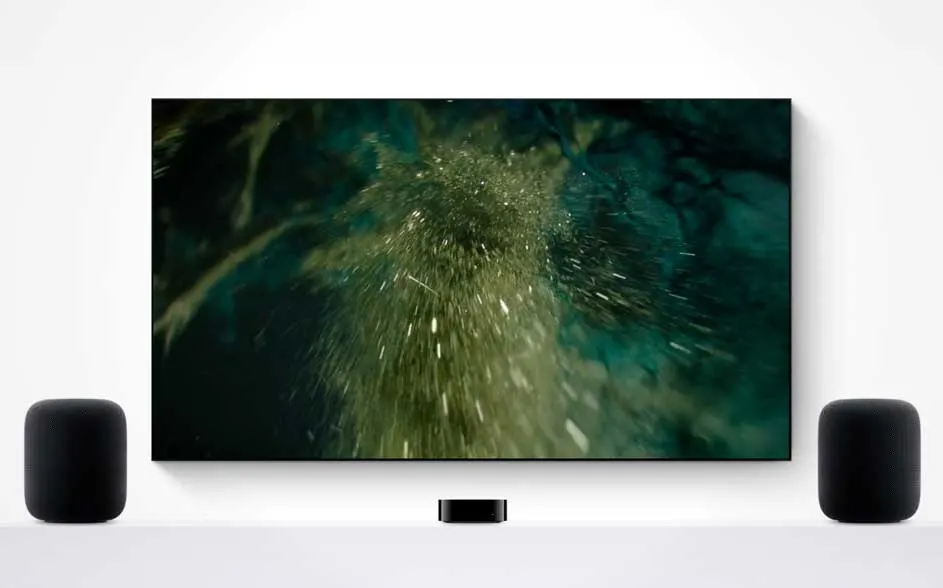 Een grote tv toont een abstracte water- of stofwolk; er staan twee zwarte speakers links en rechts en een klein kastje eronder.