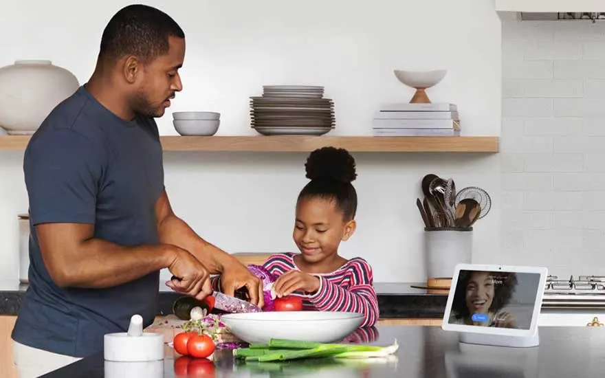 Vader en dochter koken samen terwijl een slimme display aan staat.