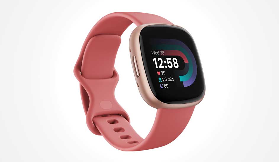 Pink smartwatch with rounded square display, gold frame and fitness stats shown as colourful arcs and bold white numbers.